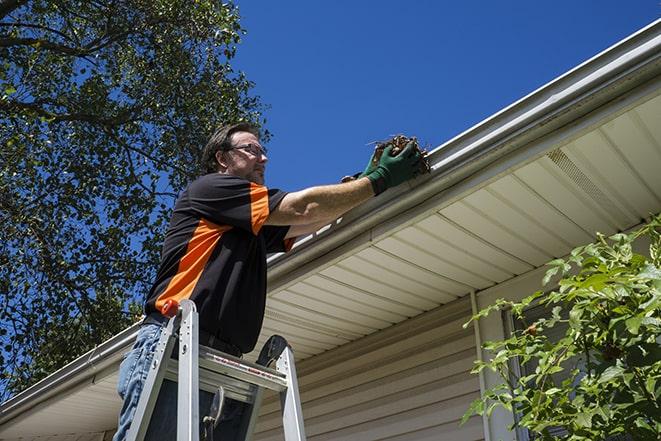 a skilled worker fixing broken gutter on a roof in Beverly Hills